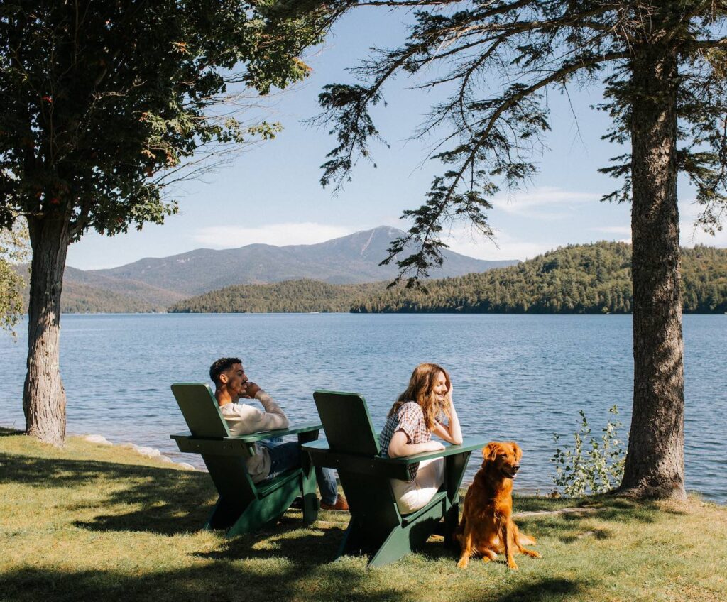 couple sitting lake side with their dog