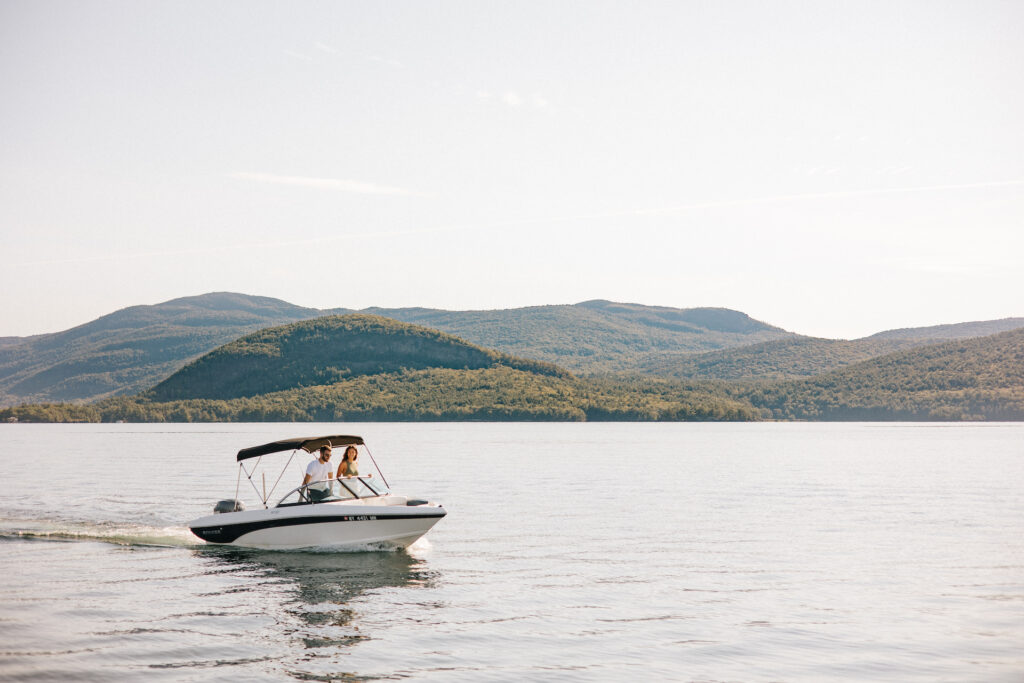 couple on a boat with mountains in the background