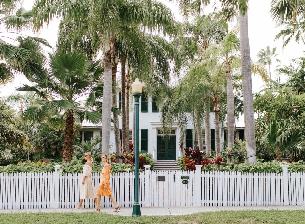 two women walking by a house