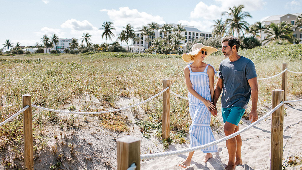 A couple walks to the beach in Delray Beach.