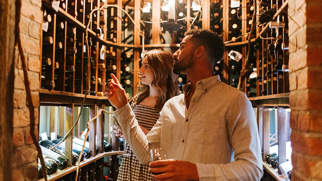 A couple looks at bottles in the wine cellar at Lake Placid Lodge.