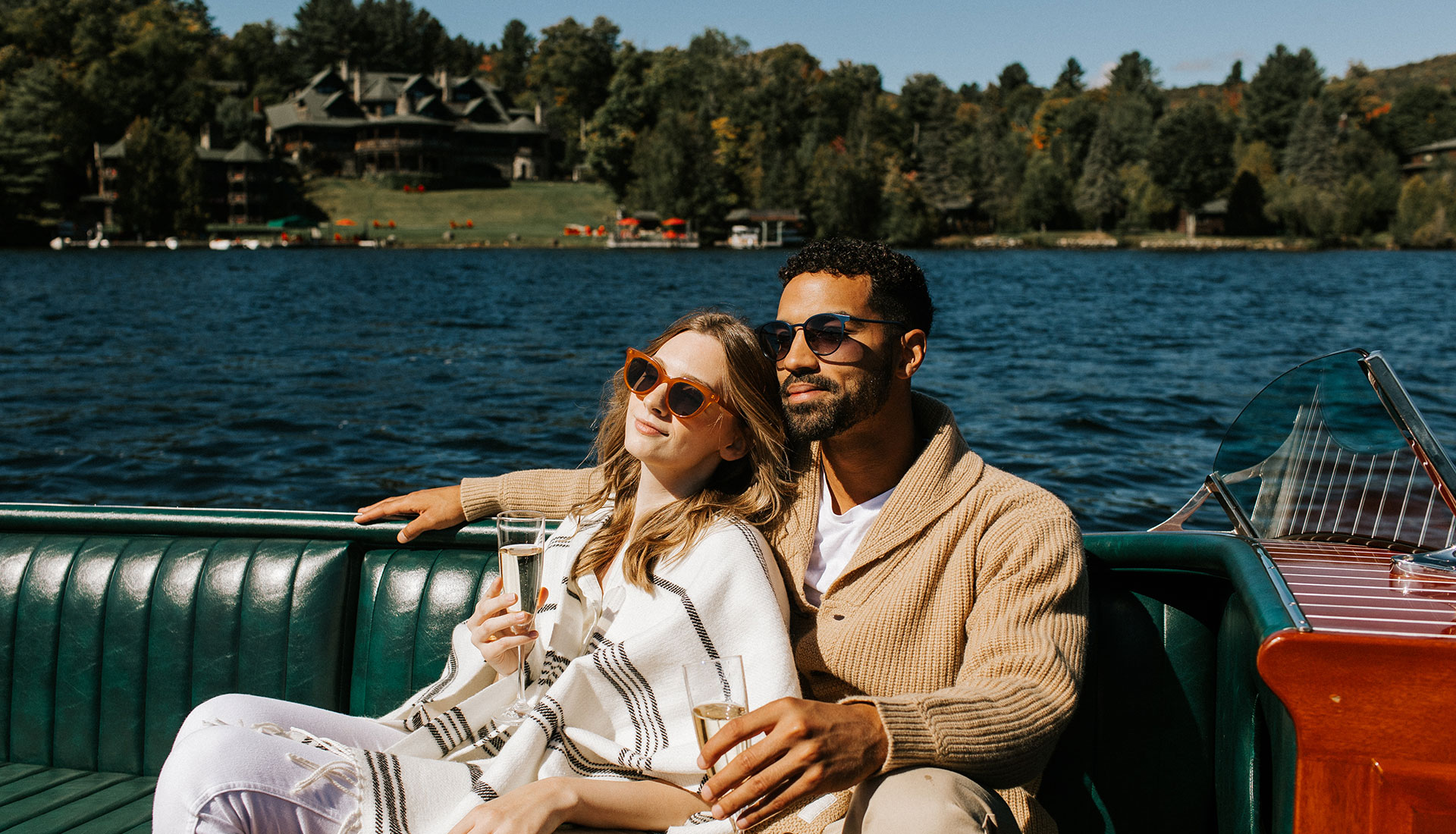 A couple snuggles on Christie, Lake Placid Lodge's antique Hacker Craft.