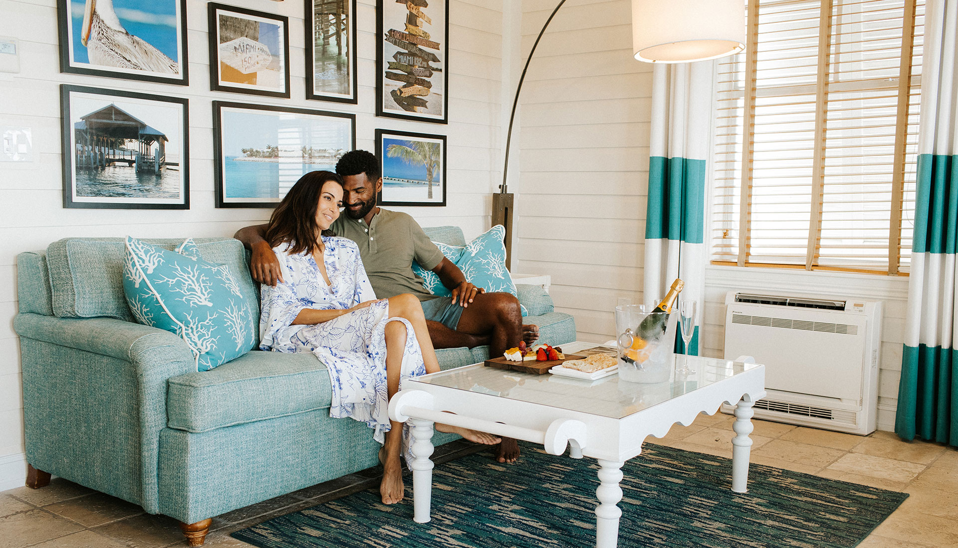 A couple snuggles on the couch in a cottage on Sunset Key.
