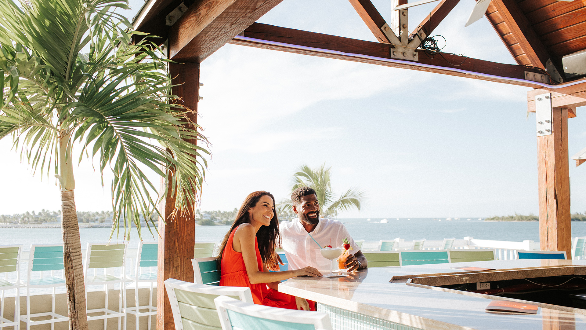 A couple has drinks at the Sunset Deck at Opal Key Resort & Marina.