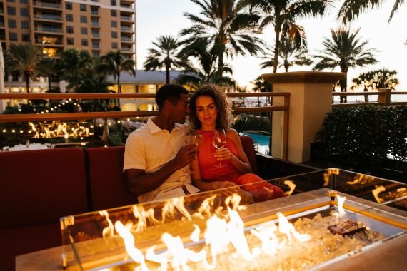 A couple sits around a firepit at Sandpearl Resort.
