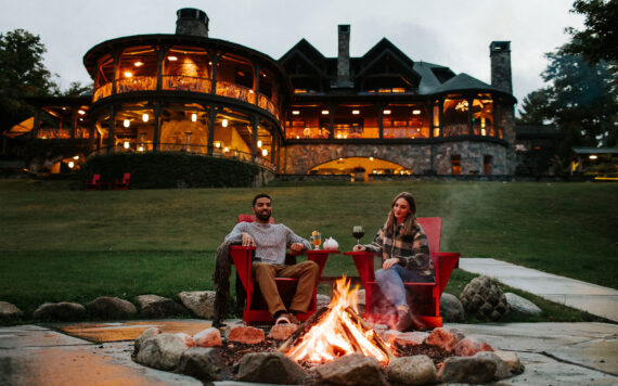 A couple relaxes at an outdoor fire pit at Lake Placid Lodge in Lake Placid, New York.
