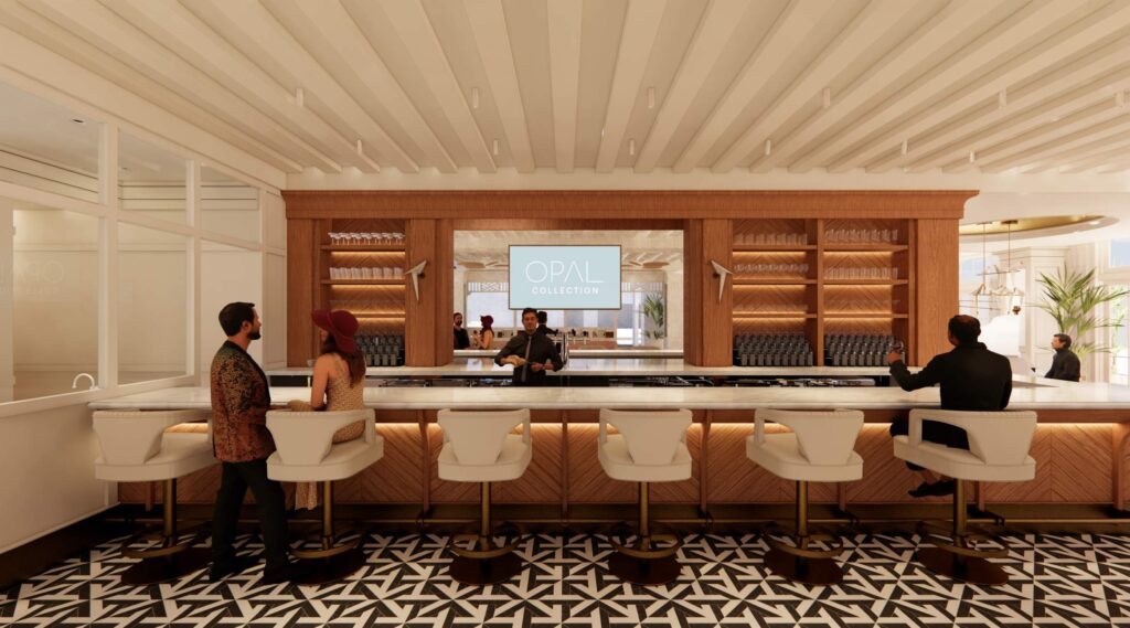 Elegant hotel bar with patterned black-and-white floor, white chairs, and a bartender serving guests. Four people sit at the counter—a standout among Naples bars—with a sign reading Opal Collection displayed behind the bar.