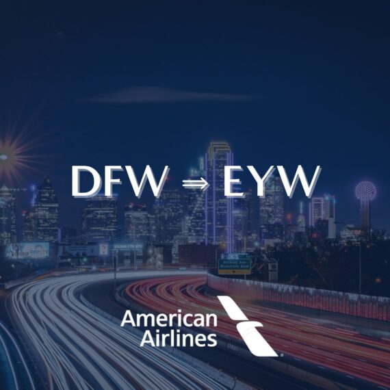 Night view of a city skyline with DFW ⇒ EYW in large text; below, the American Airlines logo appears, suggesting a new flight route. Light trails from cars are visible on a highway in the foreground.