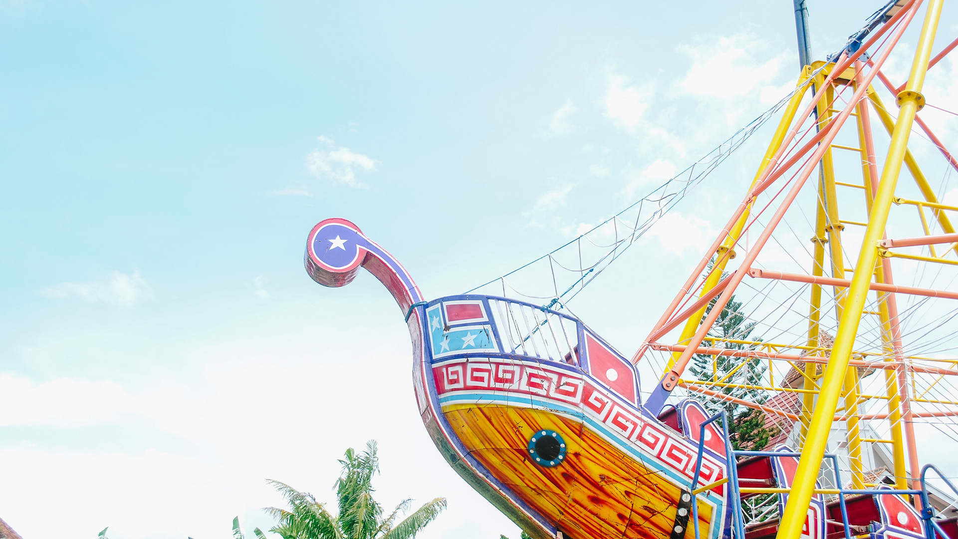 A brightly painted pirate ship amusement ride against a blue sky.