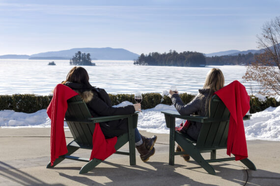 two woman enjoying wine outside on a winter day
