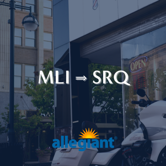 A motorcycle is parked in front of a reflective storefront in a city street. White text reads MLI ⇒ SRQ with the Allegiant logo below. Urban buildings and greenery are visible in the background.