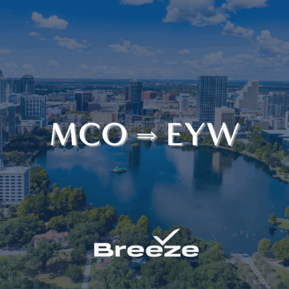 Downtown cityscape with tall buildings and a lake in the foreground; white text reads MCO ⇒ EYW above the Breeze airline logo with a checkmark.