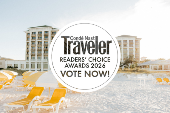 A bright beach scene with yellow lounge chairs on white sand in front of two tall resort buildings, overlaid with a circular Condé Nast Traveler Readers’ Choice Awards 2026 Vote Now! badge.