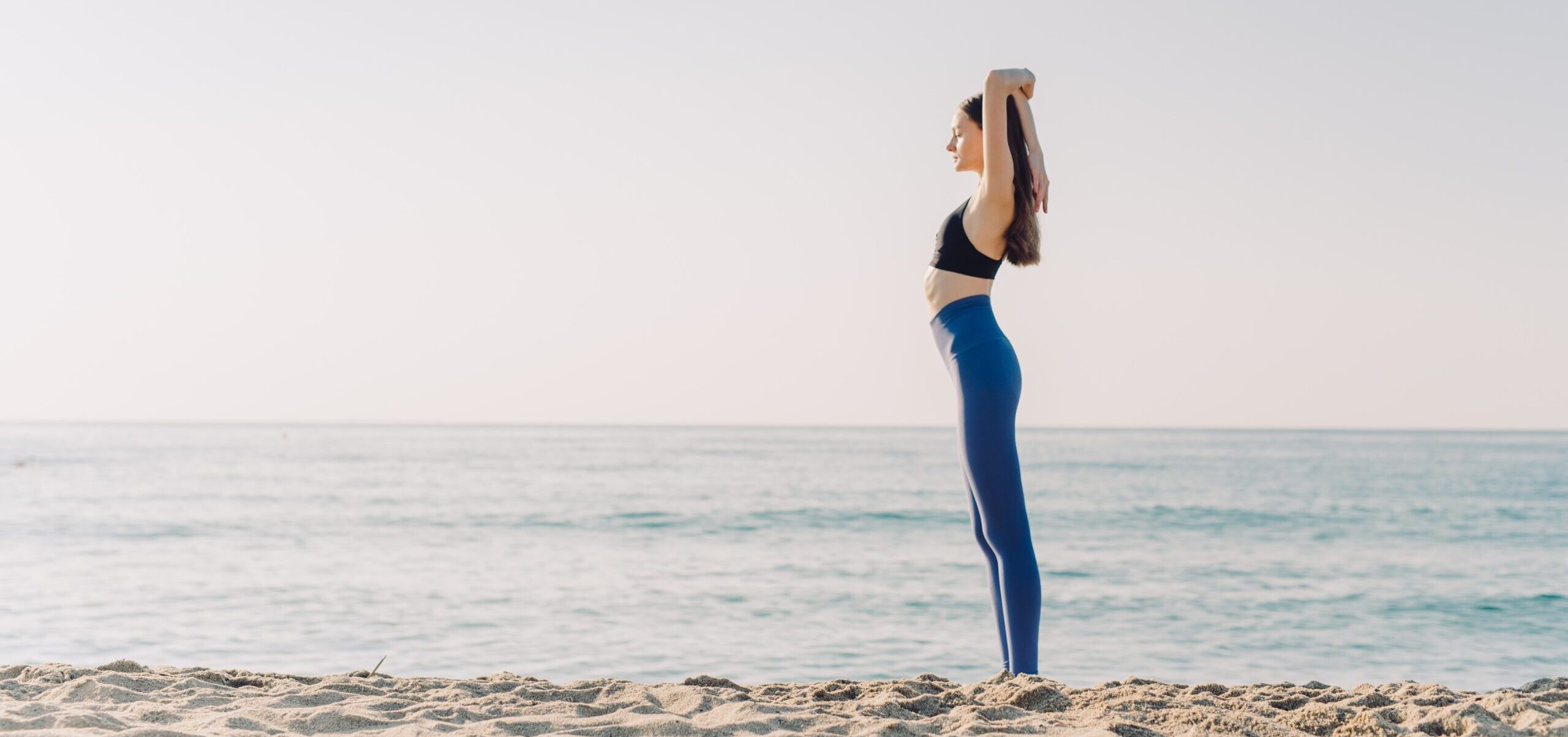 Woman doing yoga on the beach