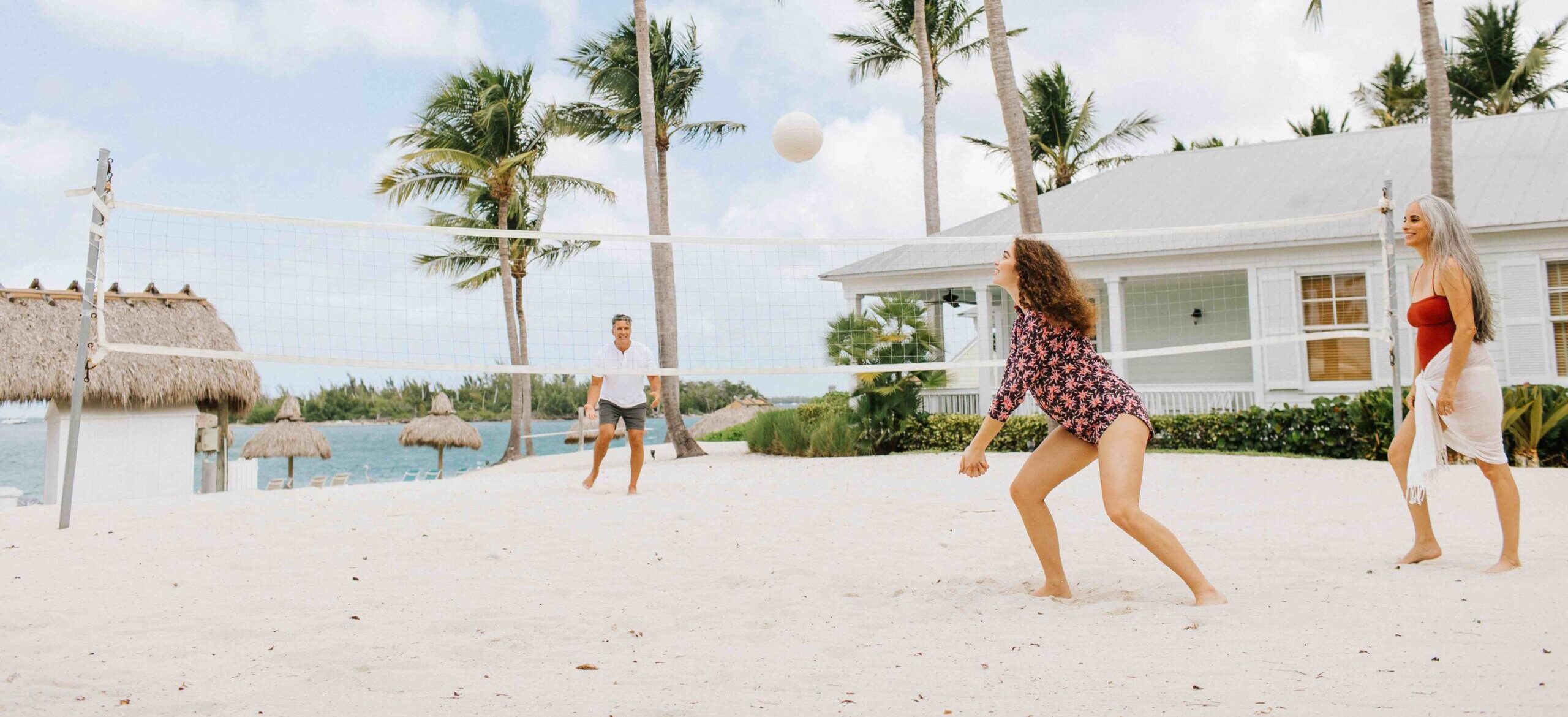 a family playing volleyball on sunset key