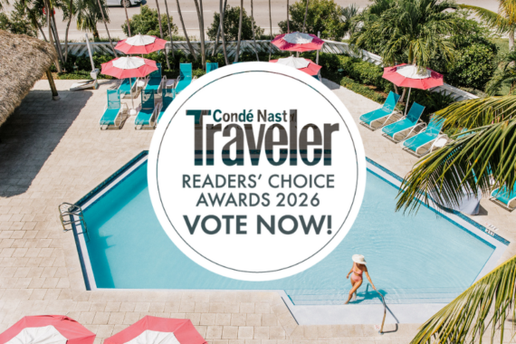 A woman in a sunhat stands by a turquoise pool surrounded by red-and-white umbrellas and loungers. Overlaid text reads: Condé Nast Traveler Readers’ Choice Awards 2026 Vote Now!.
