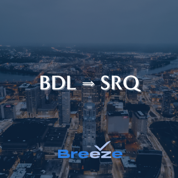 Aerial view of a cityscape at dusk with buildings illuminated. Text over the image reads BDL ⇒ SRQ at the center and Breeze with a stylized checkmark below.