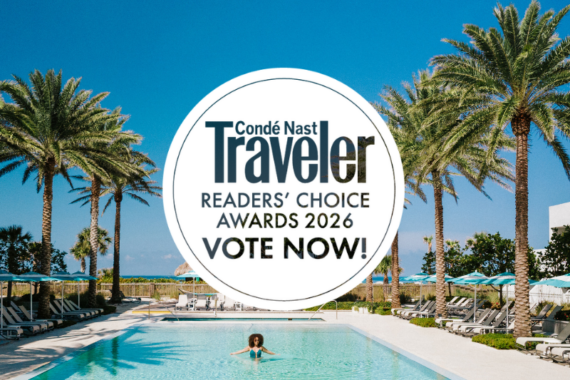 A woman relaxes in a pool surrounded by palm trees and sun loungers under a clear blue sky. Overlay text reads: Condé Nast Traveler Readers Choice Awards 2026 VOTE NOW!.