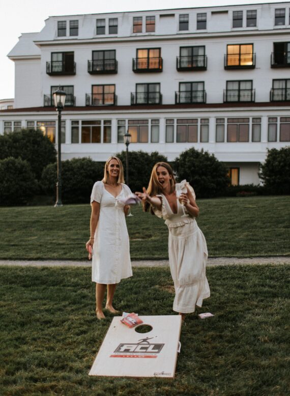 Friends playing corn hole on Wentworth by the Sea lawn
