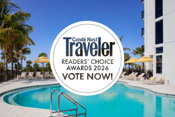 A resort pool with lounge chairs and yellow-striped umbrellas sits beneath palm trees and a clear blue sky. Overlaid text reads: Condé Nast Traveler Readers Choice Awards 2026 VOTE NOW!.