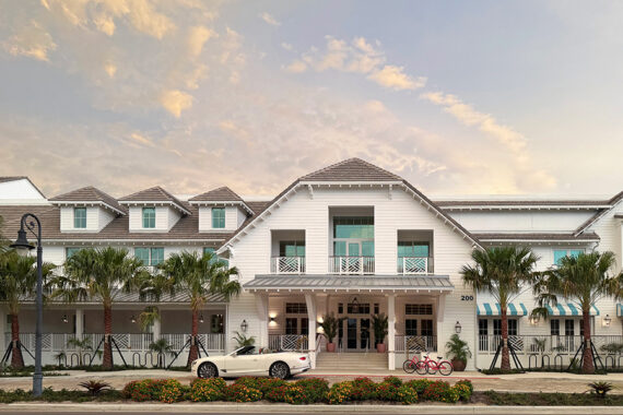 A white house with a gray roof, palm trees, a white convertible car, and red bicycles parked in front. The sky is partly cloudy, and there are shrubs and flowers along the curb.