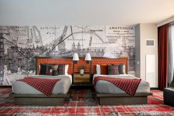 A two queen bedroom at Bobby Nashville with novel lighting and fresh wallpaper.