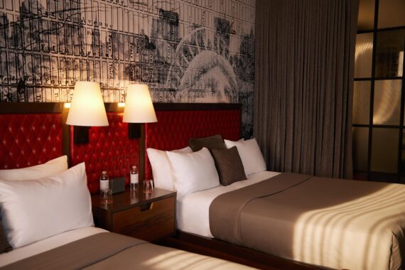 Two queen bedroom at Bobby Nashville featuring fresh wallpaper and novel lighting.