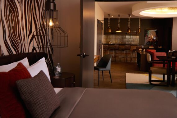 One-bedroom suite at Bobby Nashville, featuring a bed and a separate living and dining area.