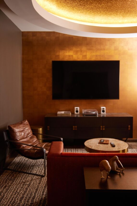 Living area of a suite at Bobby Nashville featuring a Smart TV, console, and seating arrangements.