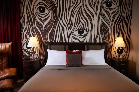 King bed at Bobby Nashville featuring zebra print wallpaper and novel lighting.
