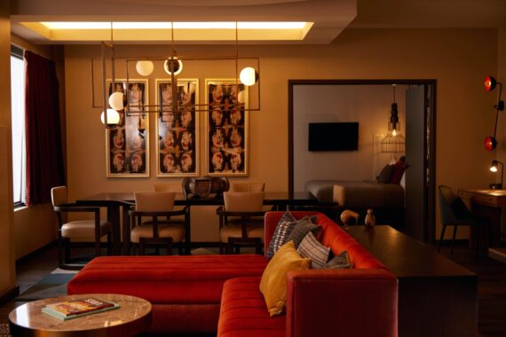 One-bedroom suite living area, featuring moody lighting, a dining table, and a sofa.