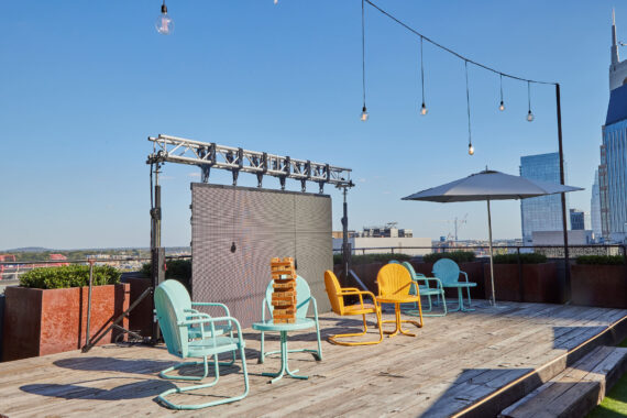 Jenga sits atop a table surrounded by colorful seating on the stage at Rooftop Lounge.