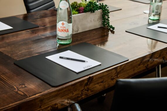 Bobby notebook, pen, and water sitting at a table in a meeting space at Bobby Nashville.