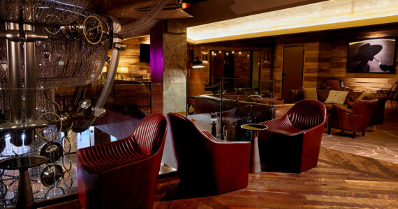 Leather couches, framed art work, and moody lighting in the Foyer at The Nash.