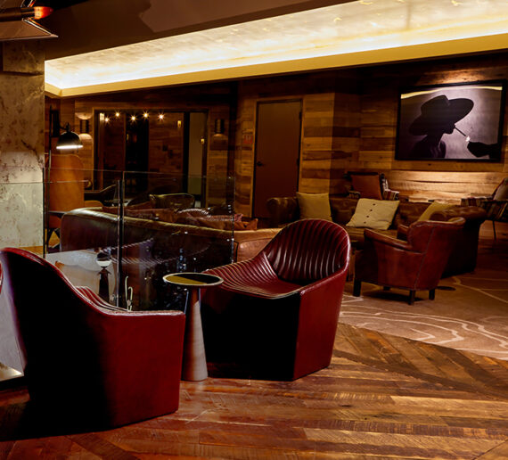 Leather couches, framed art work, and moody lighting in the Foyer at The Nash.