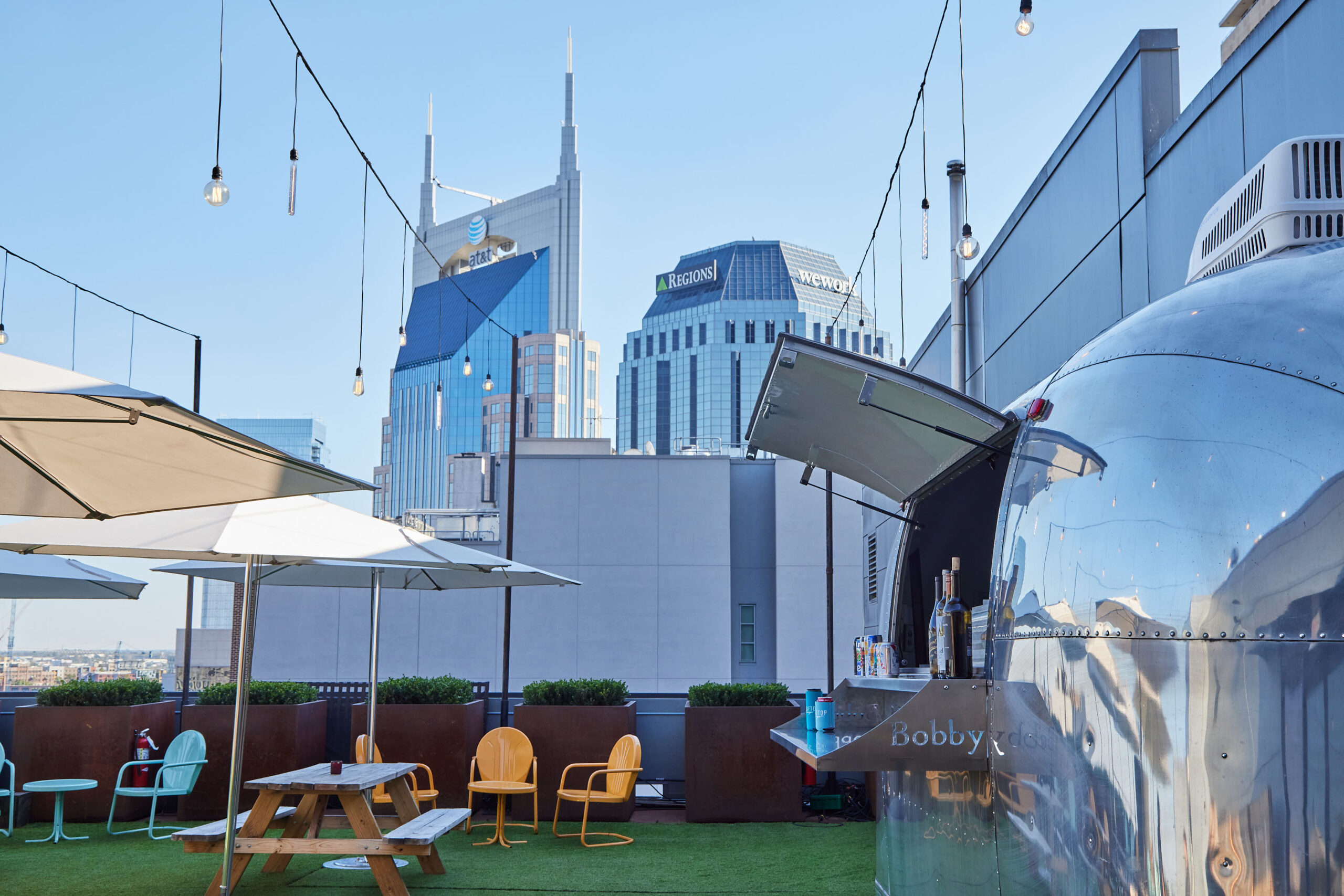 The grassy rooftop area at Bobby Nashville set with picnic tables and chairs.