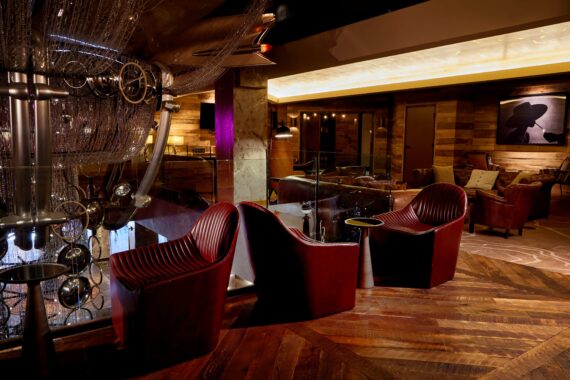 Bobby Nashville's lounge area, featuring red leather chairs, moody lighting, and Cadillac chandelier