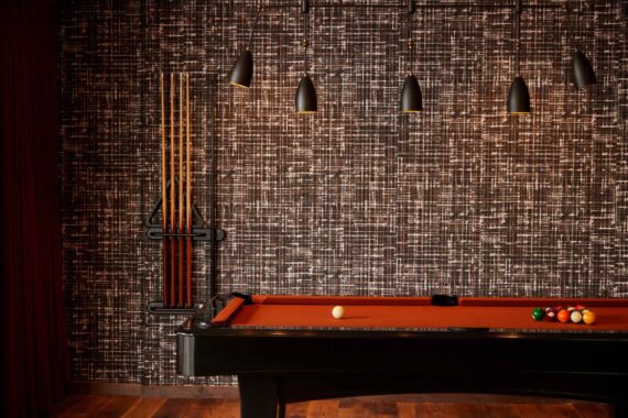 Pool table with low lighting in the living area of the two-bedroom suites at Bobby Nashville.