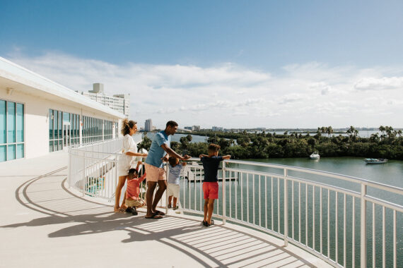 family looking over balcony at boats