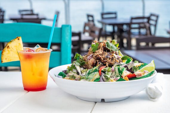 Bowl of salad and a tropical drink