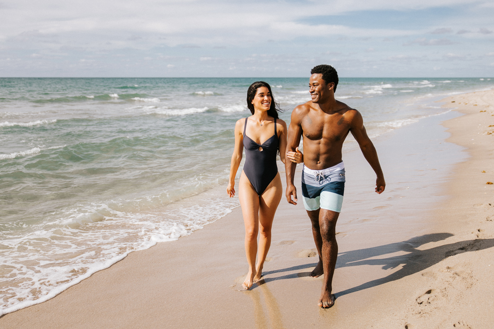 A happy couple walking down the beach