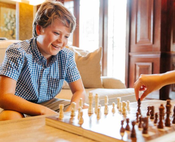 A child plays chess with his mom.